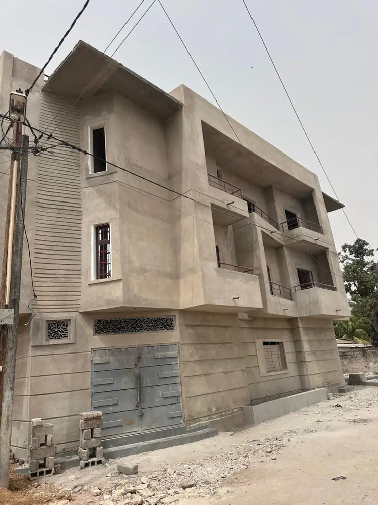 Photo du chantier : façade latérale enduite, claustras et garde-corps posés